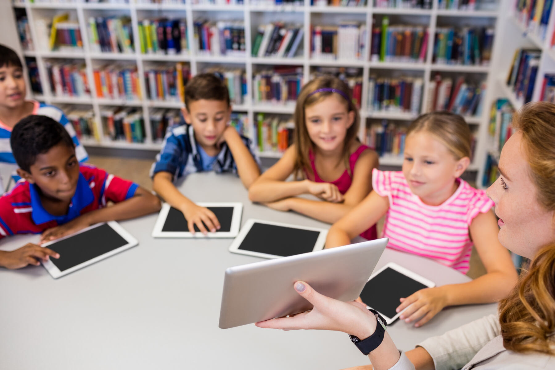 Young students reading together in a classroom library